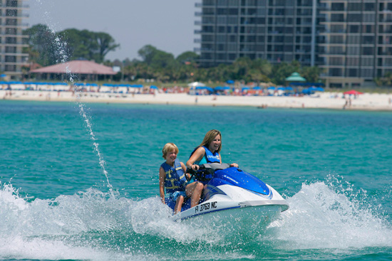 Vacationers riding a Jet ski rental in Panama City Beach, Florida.